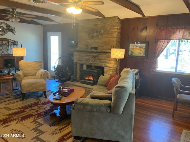 living room with ceiling fan, a fireplace, hardwood / wood-style floors, and vaulted ceiling with beams