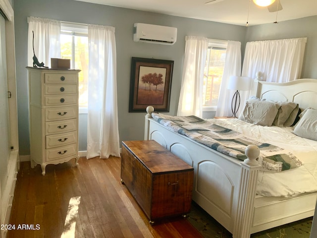 bedroom featuring dark wood-type flooring and a wall unit AC