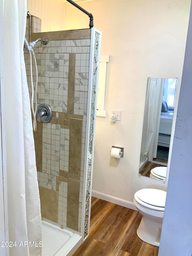 bathroom with a shower with curtain, hardwood / wood-style flooring, and toilet