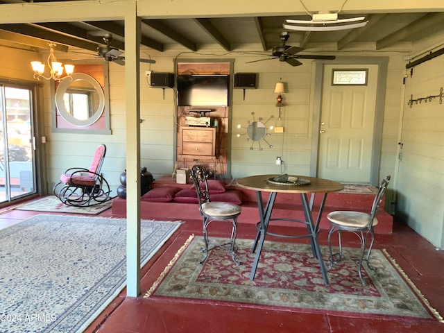 dining room with beamed ceiling and ceiling fan with notable chandelier