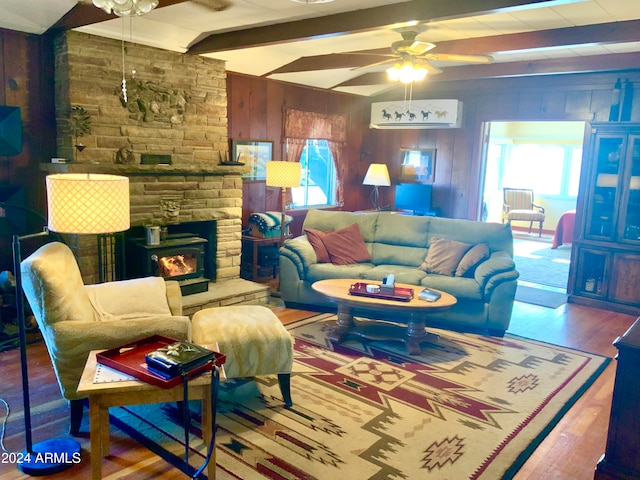 living room with ceiling fan, wooden walls, hardwood / wood-style floors, and a wealth of natural light