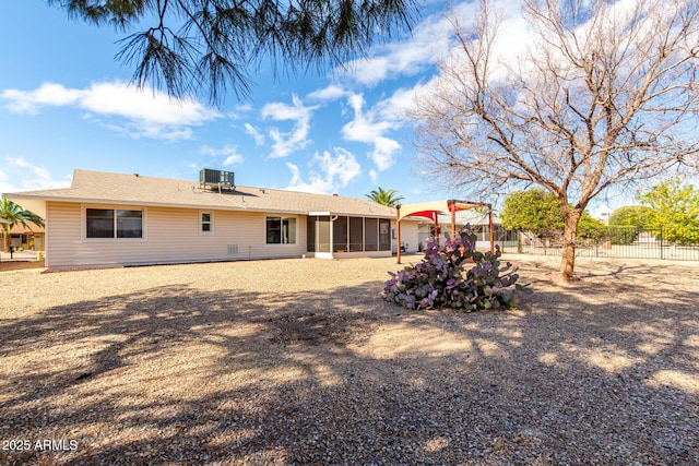 back of property featuring central air condition unit, fence, and a sunroom