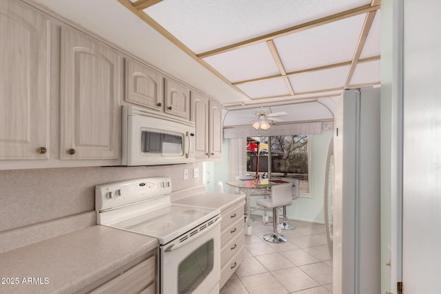 kitchen featuring light tile patterned floors, white appliances, ceiling fan, and light countertops