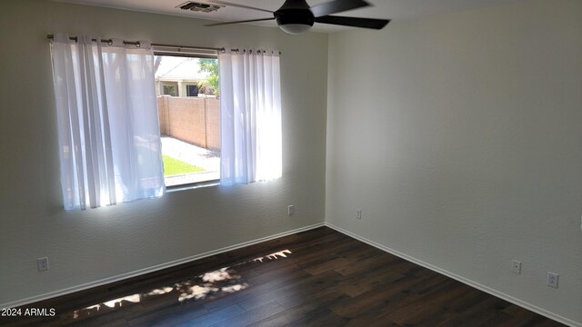 spare room with dark hardwood / wood-style flooring and ceiling fan