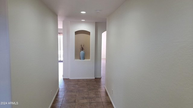 hallway with recessed lighting, baseboards, and arched walkways