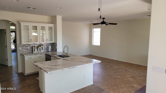 kitchen featuring tasteful backsplash, kitchen peninsula, sink, ceiling fan, and white cabinets