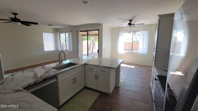 kitchen featuring white refrigerator, sink, kitchen peninsula, ceiling fan, and stainless steel dishwasher