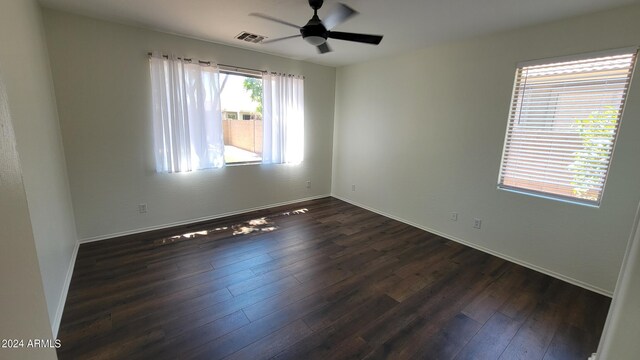 spare room with dark wood-type flooring and ceiling fan