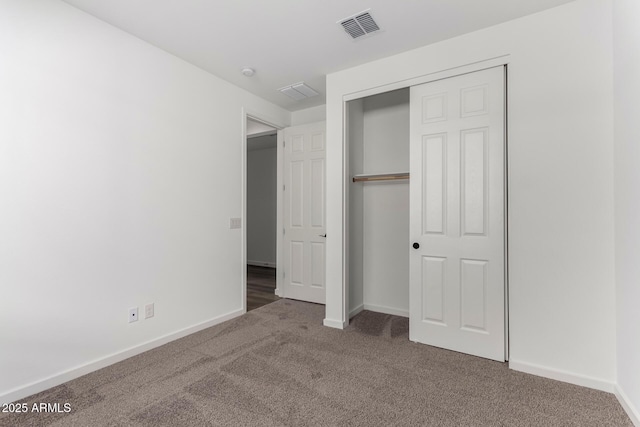 unfurnished bedroom featuring dark carpet and a closet