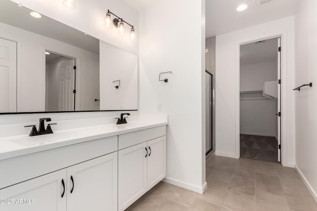 bathroom featuring tile patterned flooring, an enclosed shower, and vanity