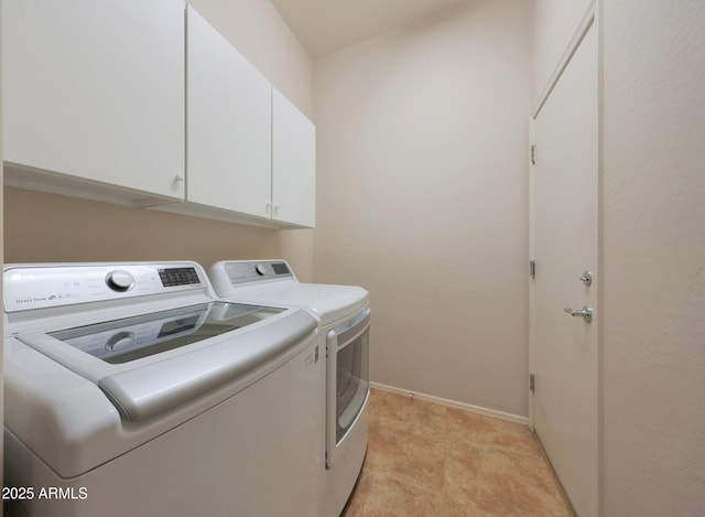 laundry room featuring washer and clothes dryer and cabinets