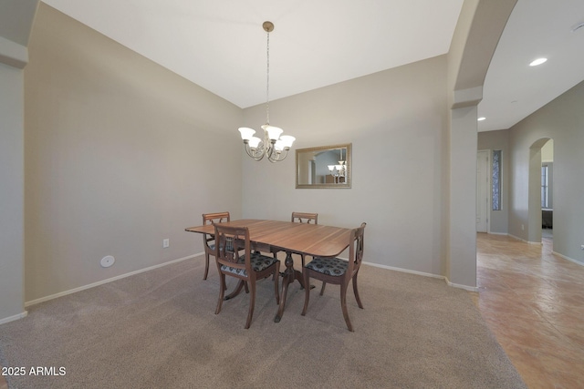 carpeted dining space with a chandelier