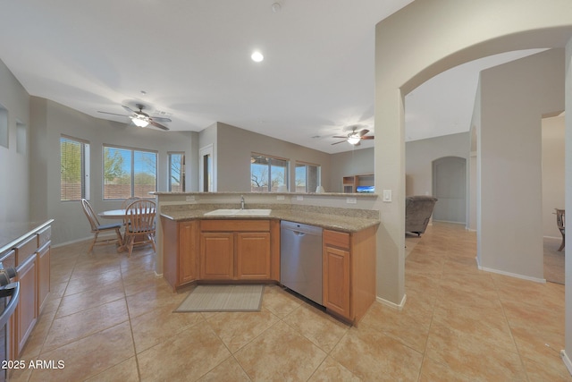 kitchen with sink, stainless steel dishwasher, ceiling fan, and light stone countertops