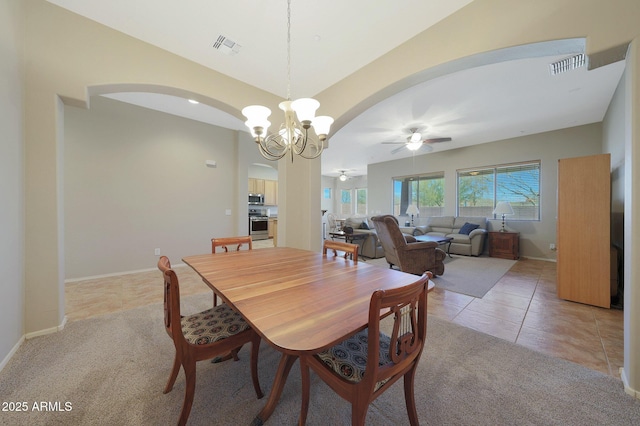 tiled dining area with vaulted ceiling and ceiling fan with notable chandelier