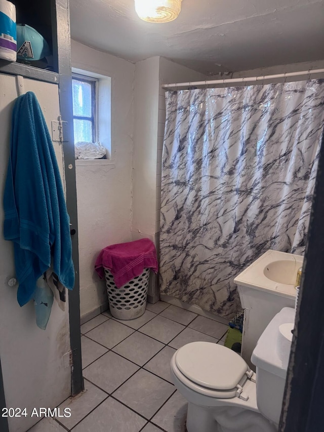 bathroom featuring tile flooring, vanity, and toilet