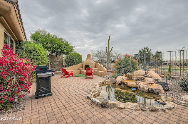 view of patio with an outdoor fireplace and area for grilling