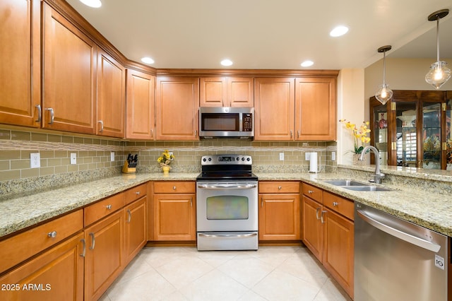 kitchen featuring stainless steel appliances, decorative light fixtures, sink, and backsplash