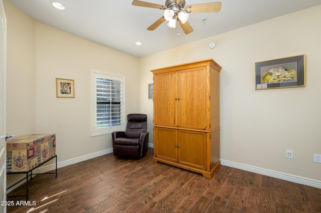 living area featuring dark wood-type flooring and ceiling fan