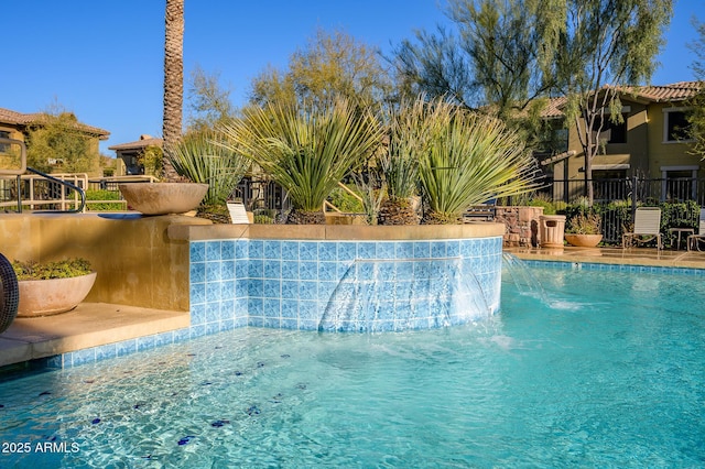 view of swimming pool with pool water feature