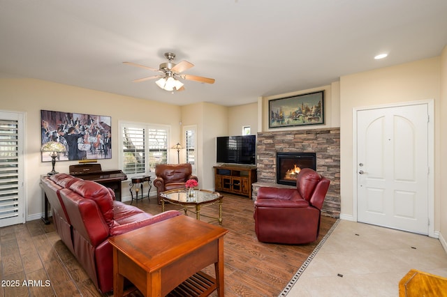 living room featuring wood-type flooring, a fireplace, and ceiling fan