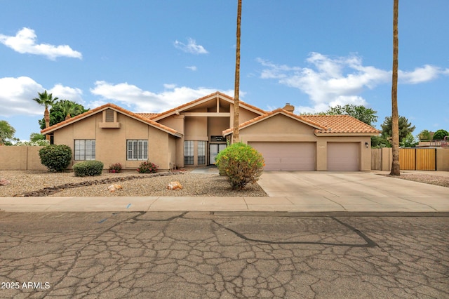 8913 S Forest Ave, Tempe, AZ 85284 - view of front of house featuring stucco siding, an attached garage, a tile roof, and driveway