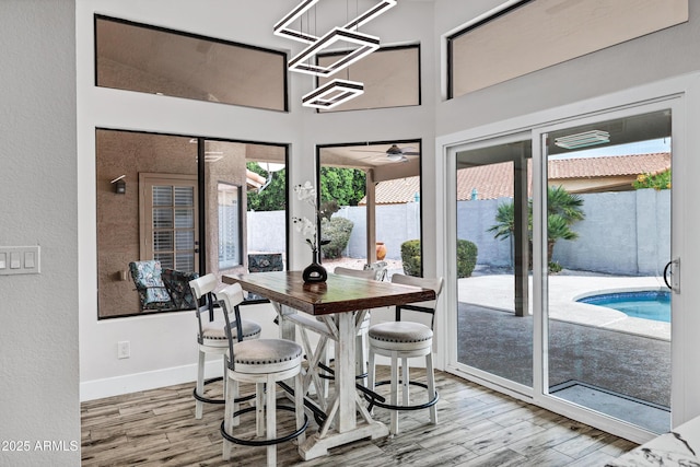 8913 S Forest Ave, Tempe, AZ 85284 - dining area featuring wood finished floors, baseboards, a textured wall, a high ceiling, and ceiling fan