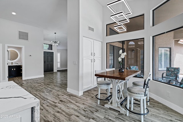 8913 S Forest Ave, Tempe, AZ 85284 - dining space with a chandelier, a towering ceiling, baseboards, and wood finished floors