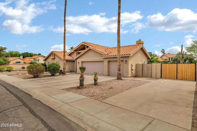8913 S Forest Ave, Tempe, AZ 85284 - view of front facade featuring a gate, stucco siding, a tile roof, a chimney, and a garage