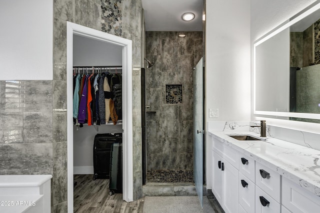 8913 S Forest Ave, Tempe, AZ 85284 - bathroom featuring a shower stall, double vanity, a walk in closet, and wood finished floors