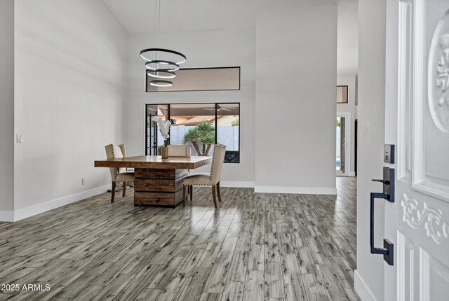 8913 S Forest Ave, Tempe, AZ 85284 - dining area with wood finished floors, baseboards, a chandelier, and a high ceiling