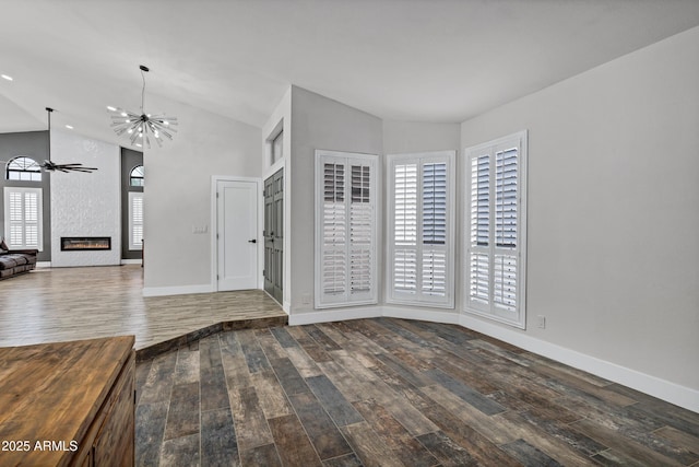 8913 S Forest Ave, Tempe, AZ 85284 - empty room with wood finished floors, lofted ceiling, ceiling fan, a large fireplace, and a chandelier