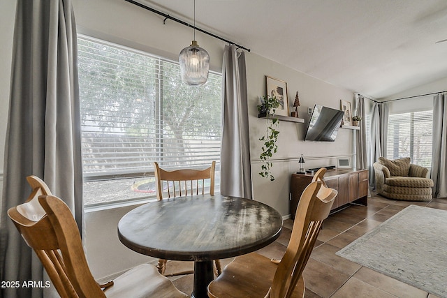 tiled dining space featuring lofted ceiling