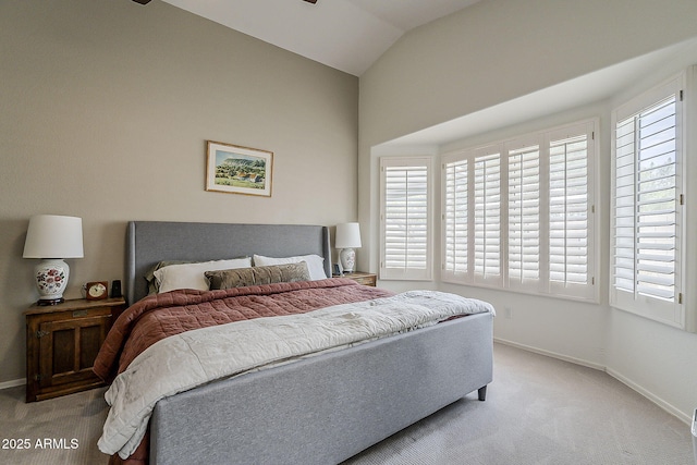 carpeted bedroom featuring lofted ceiling and baseboards