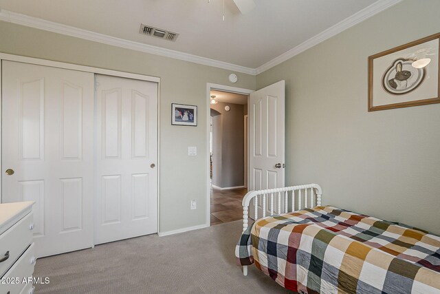 bedroom featuring carpet flooring, baseboards, visible vents, a closet, and crown molding