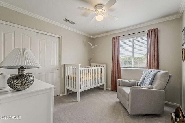 bedroom featuring a nursery area, a closet, light colored carpet, ornamental molding, and visible vents