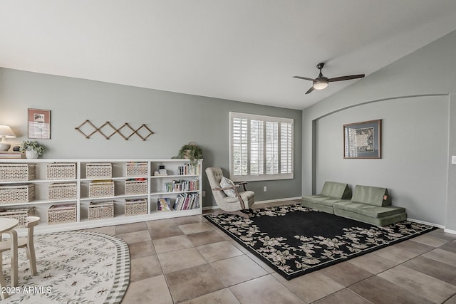 sitting room featuring vaulted ceiling, baseboards, tile patterned flooring, and ceiling fan