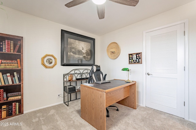 carpeted home office featuring ceiling fan