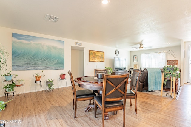 dining room with ceiling fan and light wood-type flooring