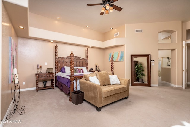 bedroom with carpet, ceiling fan, and a towering ceiling