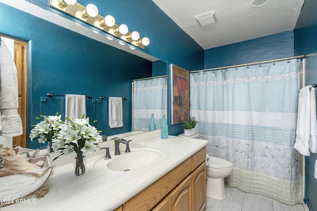 bathroom with tile patterned flooring, vanity, and toilet