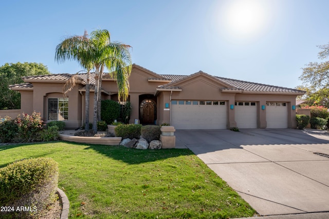 mediterranean / spanish-style home with a front yard and a garage