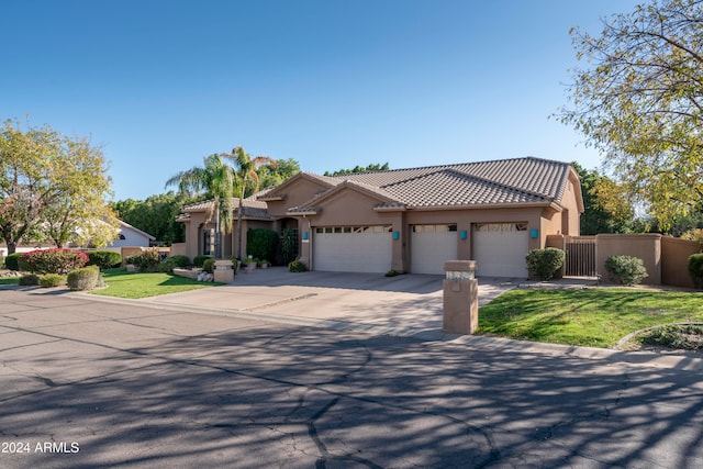 mediterranean / spanish home featuring a garage and a front lawn