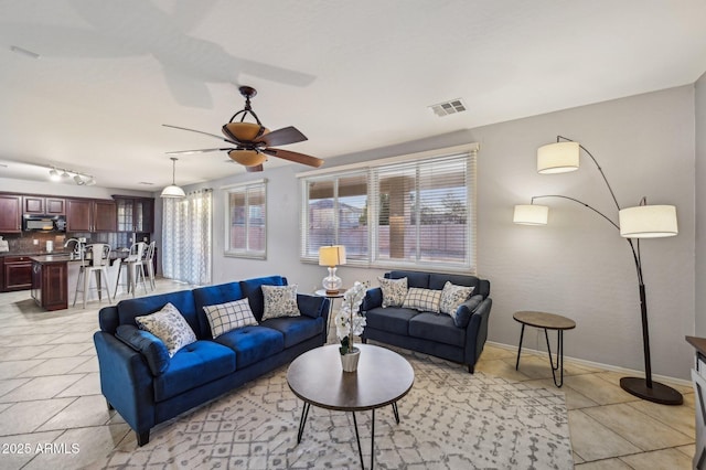 living room with ceiling fan and light tile patterned floors