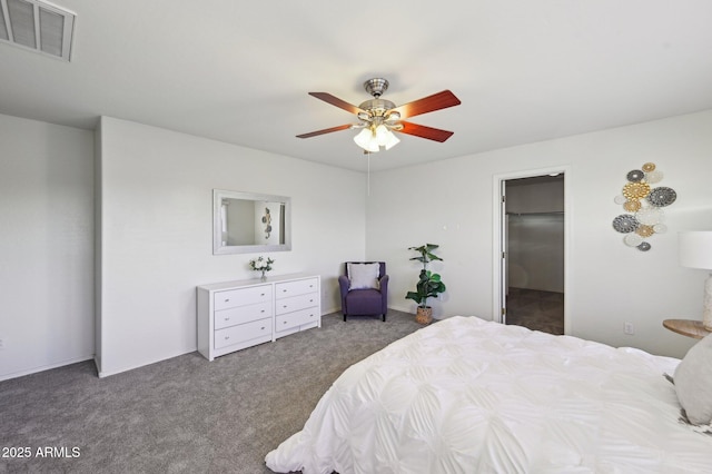 carpeted bedroom with ceiling fan and a spacious closet