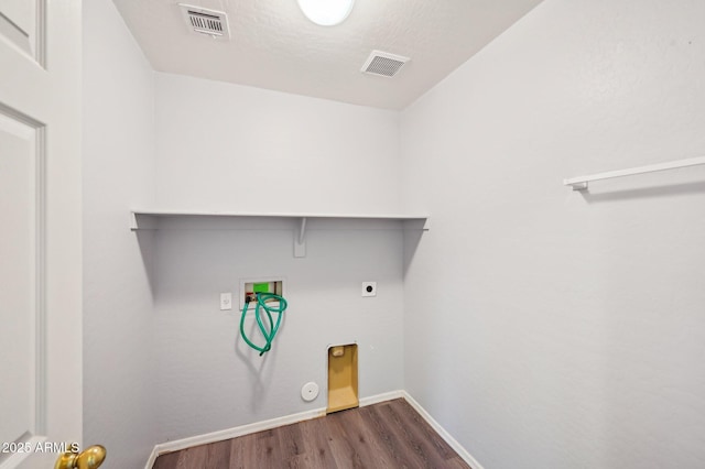 clothes washing area with gas dryer hookup, washer hookup, electric dryer hookup, dark wood-type flooring, and a textured ceiling