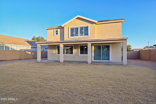 rear view of house with a patio and a lawn