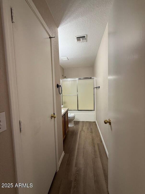 hallway with dark wood-type flooring and a textured ceiling