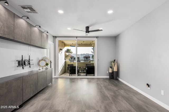 interior space with ceiling fan and dark brown cabinetry