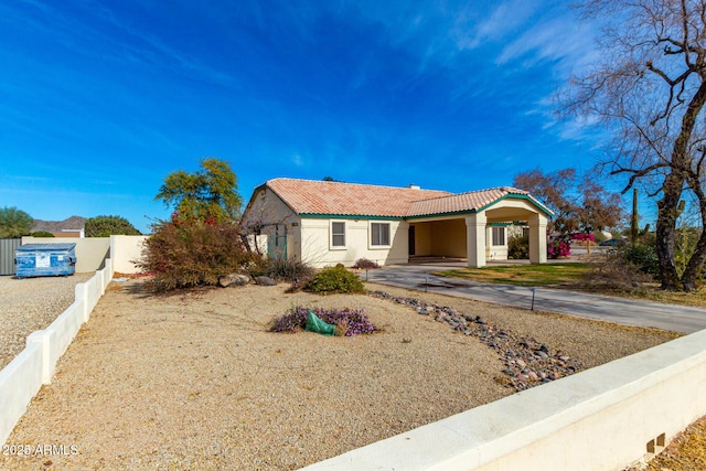 view of front of property with a tiled roof, fence, and stucco siding