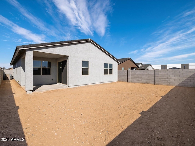 back of property with a patio area, a fenced backyard, and stucco siding